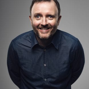 Man leans in to camera smiling