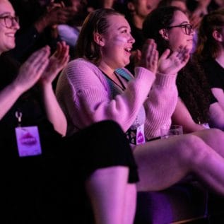 Audience clapping at GENFest