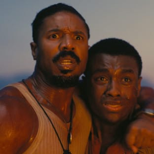 2 black men in brown tank tops huddled together looking scared