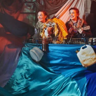 Two girl stand on a ship under coloured lighting