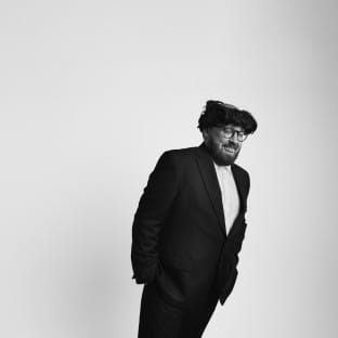Man in hat and coat tilting sideways