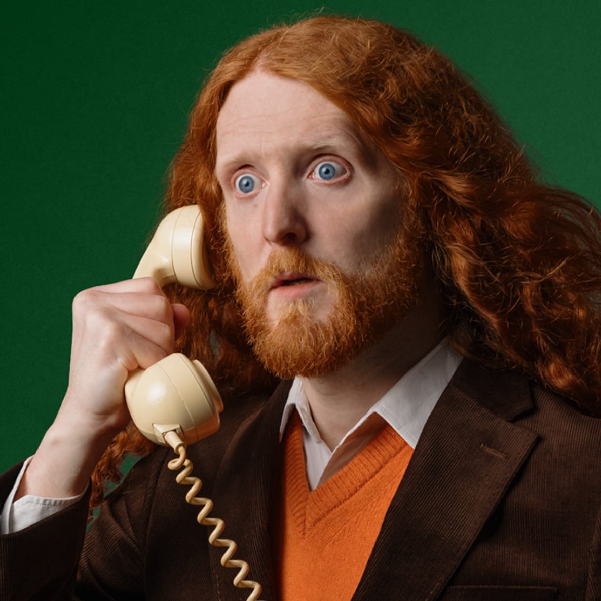 Man in suit holding an old telephone