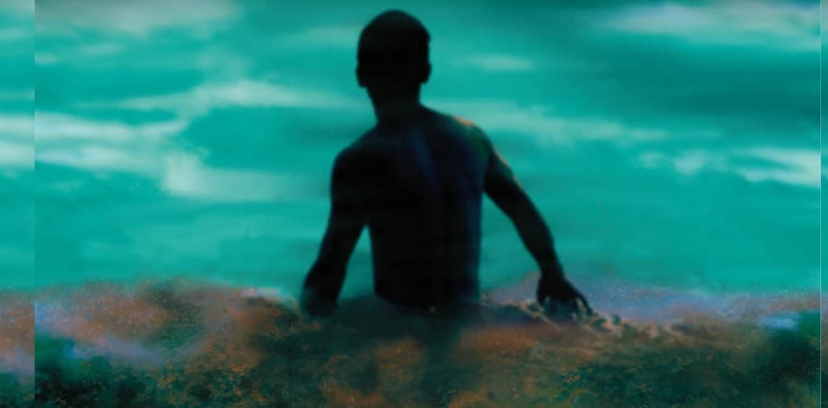 Boy walking into ocean