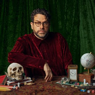 Man sitting at desk with skull and globe on it