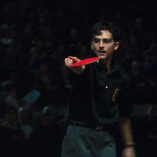 Man with glasses holding ping pong bat