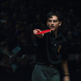 Man with glasses holding ping pong bat