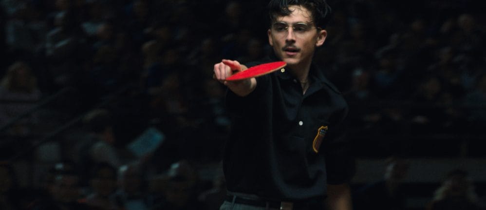 Man with glasses holding ping pong bat