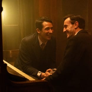 Two men in suits laughing