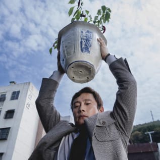Man holding a flower pot up