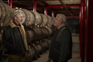 Two men next to wooden barrels