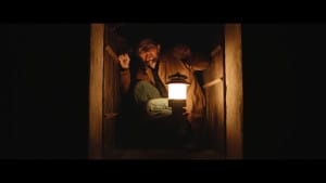 A man in a cramped room with a torch