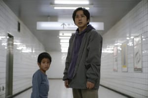 A man and a boy standing in a white hallway